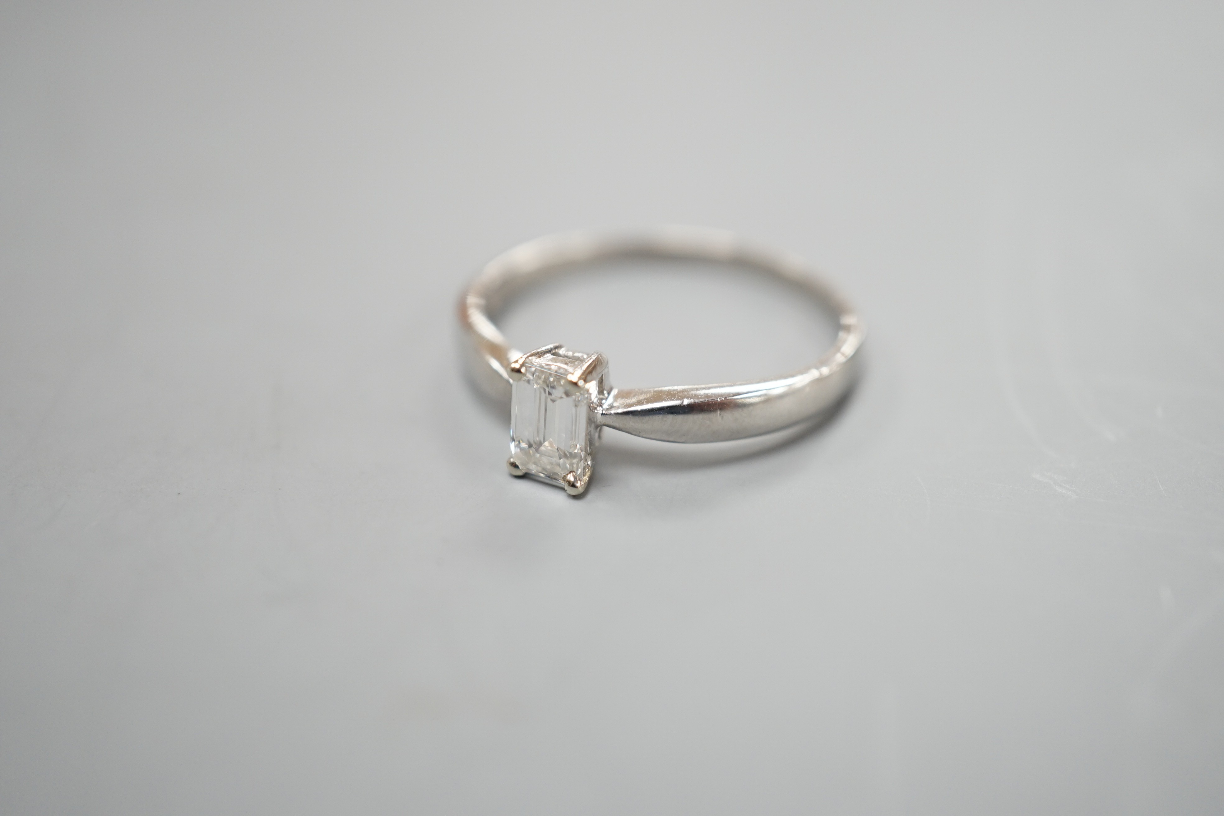 A modern platinum and solitaire emerald cut diamond set ring, size P/Q, gross weight 3.2 grams
